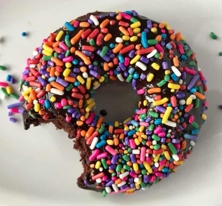 A chocolate donut with sprinkles.