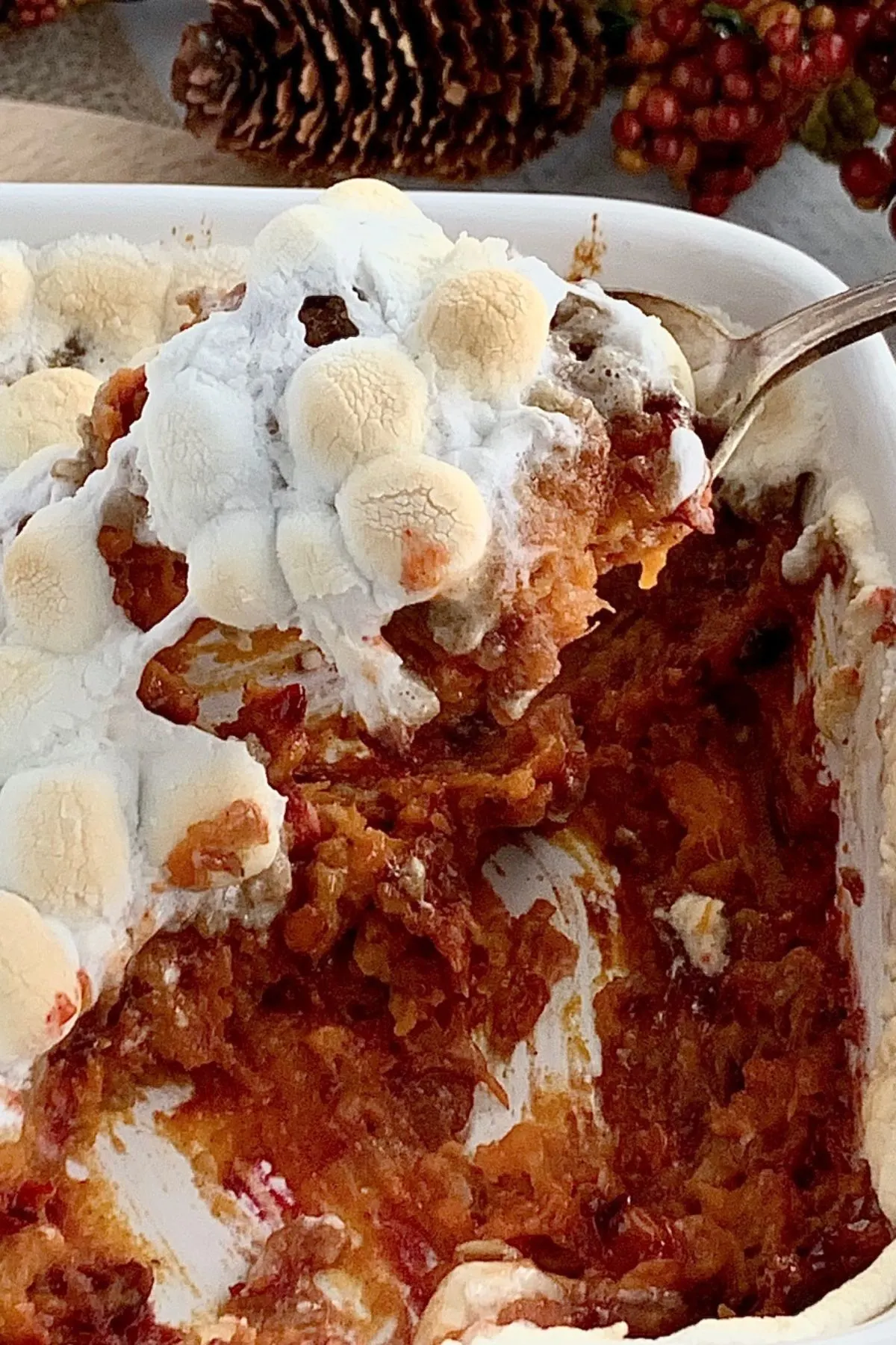 A serving spoon scooping out some dairy free sweet potato casserole of the baking dish.