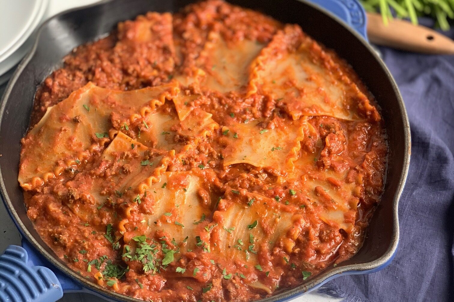 A skillet filled with tender lasagn noodles broken into pieces in a meaty marinara sauce.
