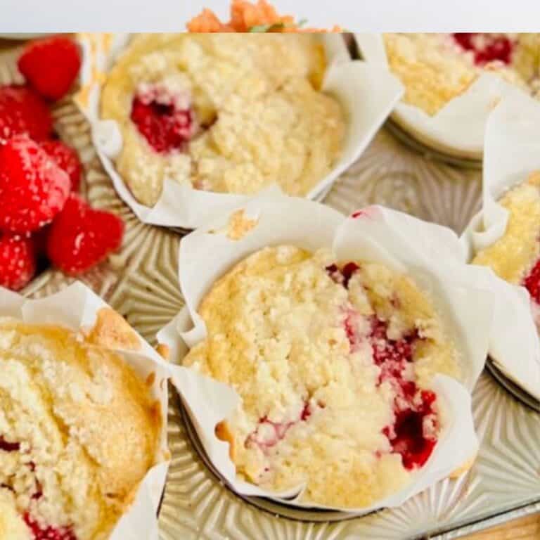 A muffin pan with lined Gluten Free Raspberry Muffins.