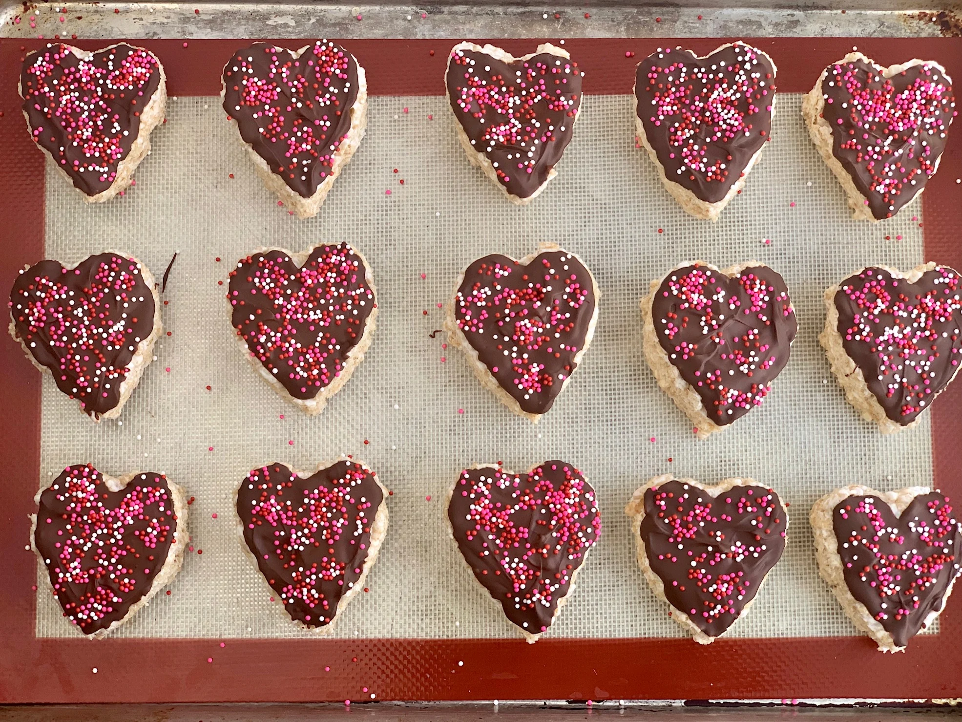 Heart shaped rice krispie with melted chocolate and sprinkles on the top