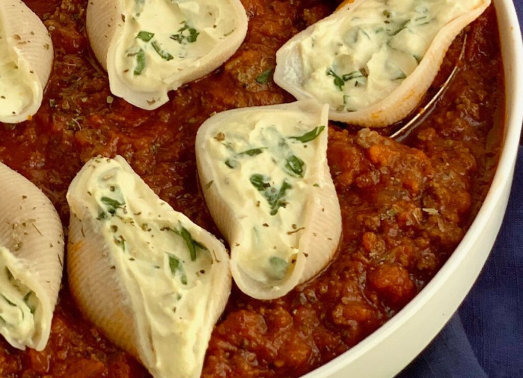 Looking down on gluten free stuffed shells in meat sauce.