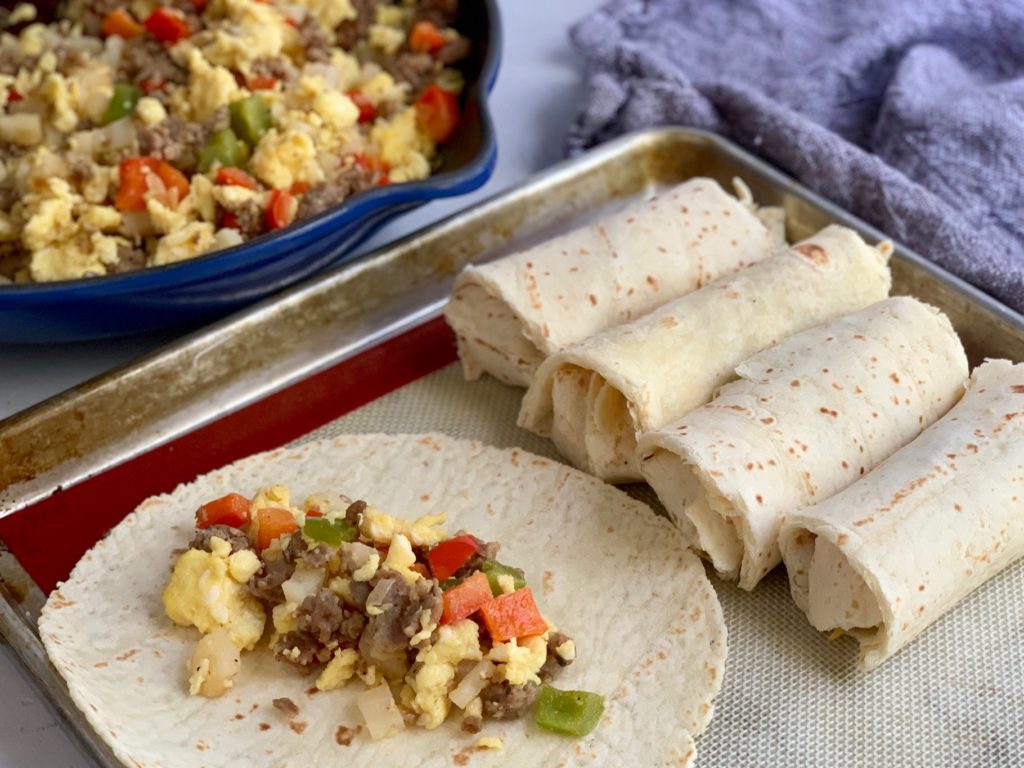 sausage, eggs, onions, diced potatoes, and bell peppers on a gluten free tortilla