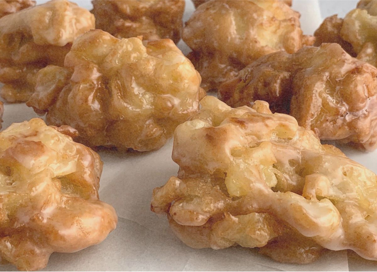 A few deep-fried dairy free apple fritters and wax paper.