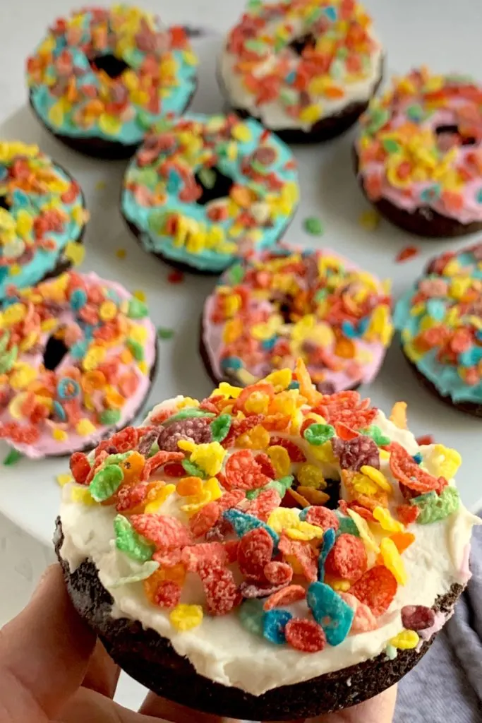 Chocolate donuts with frosting and fruity pebble cereal