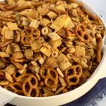 A large bowl of chex mix with peanuts, pretzels, and cereal.