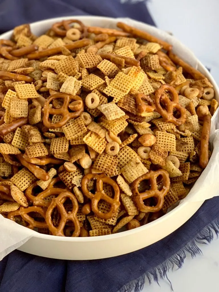 A large bowl of chex mix with pretzels, circle o cereal, chex mix, corn mix, and peanuts.