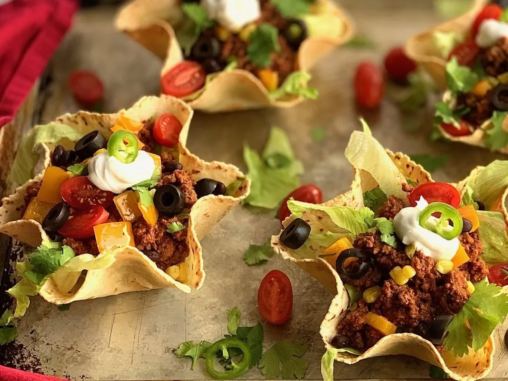 taco meat and toppings in a taco salad shell