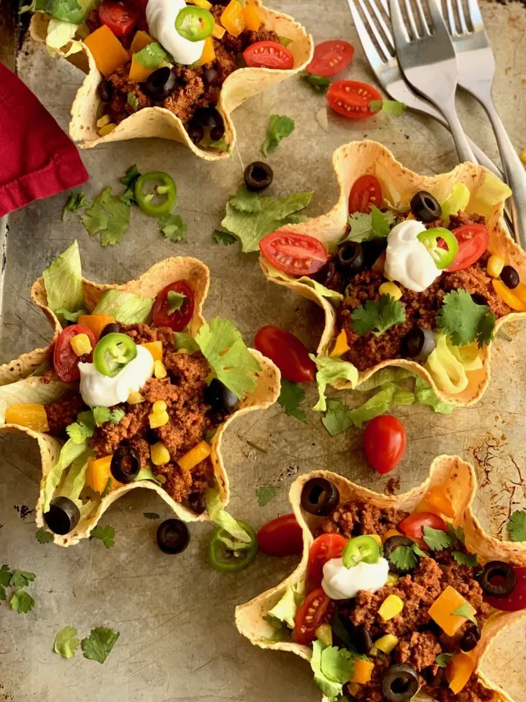 taco meat and toppings in a taco salad shell.