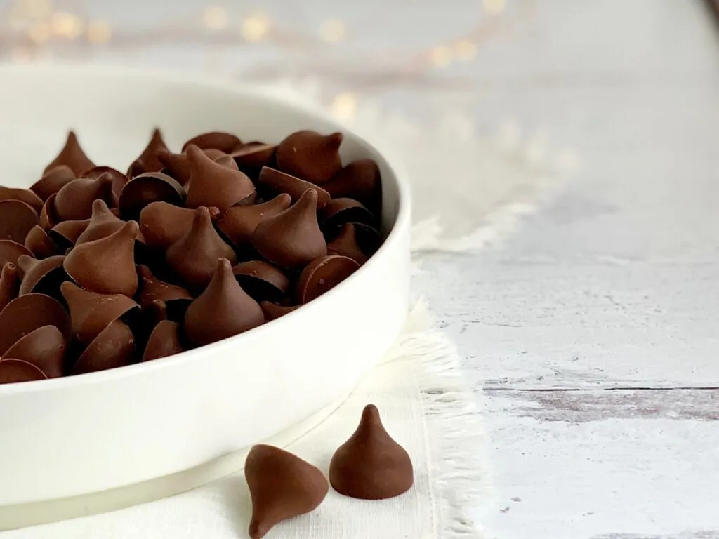 A large white serving platter filled with chocolate kisses