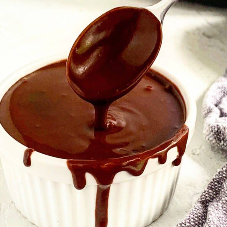A spoon stirring dairy-free ganache in a bowl.
