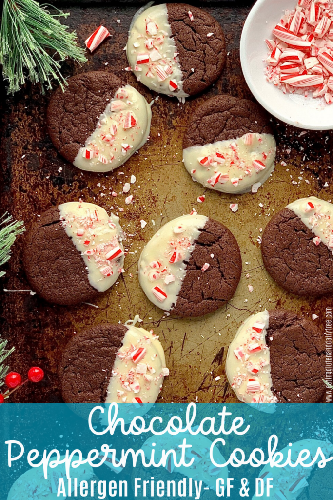 chocolate peppermint cookies dipped in white chocolate and sprinkled with crushed candy canes on a cookie sheet