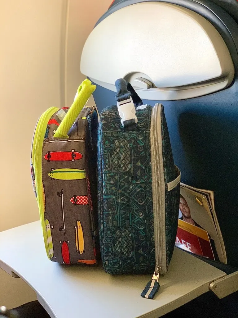 two food coolers sitting on an airplane tray table