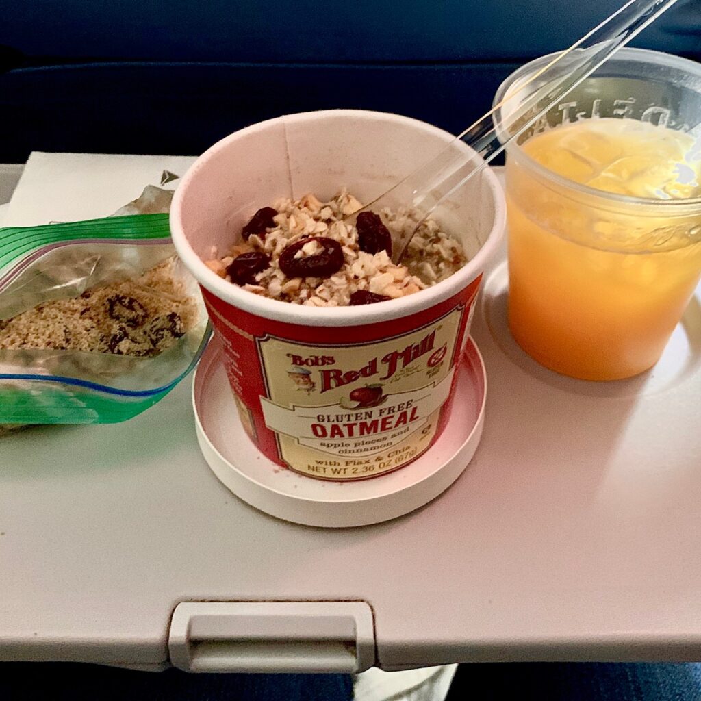 oatmeal and orange juice on an airplane tray table