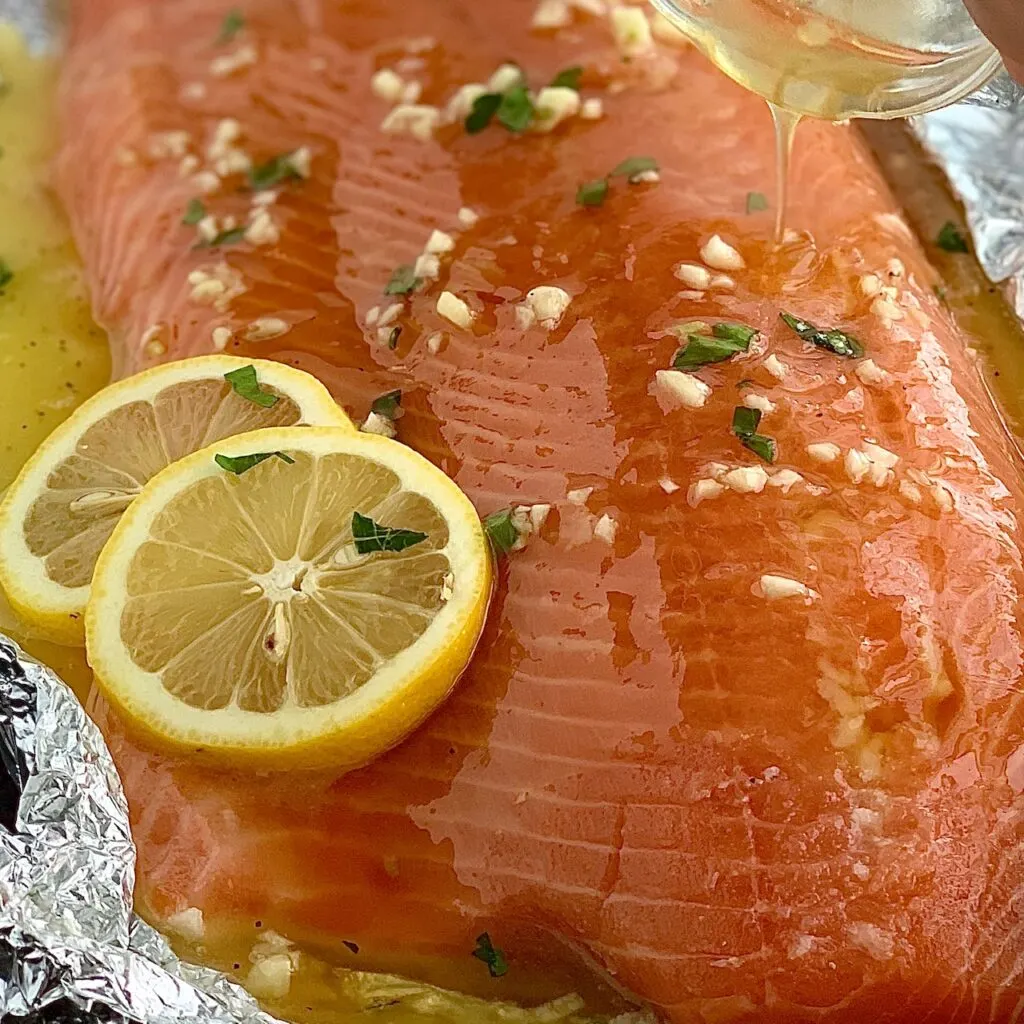 Salmon with glaze being drizzled on it 