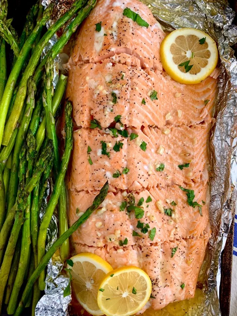 salmon in tin foil with lemon slices and asparagus