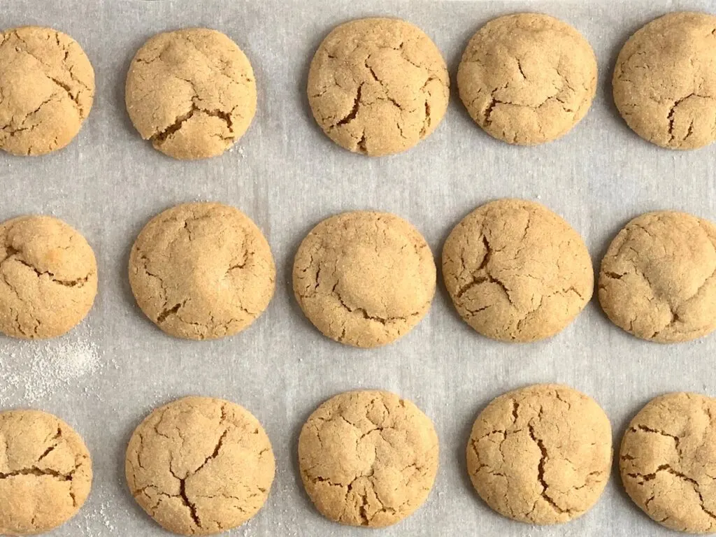 Peanut butter blossom cookies removed from the oven before placing chocolate hearts on top.