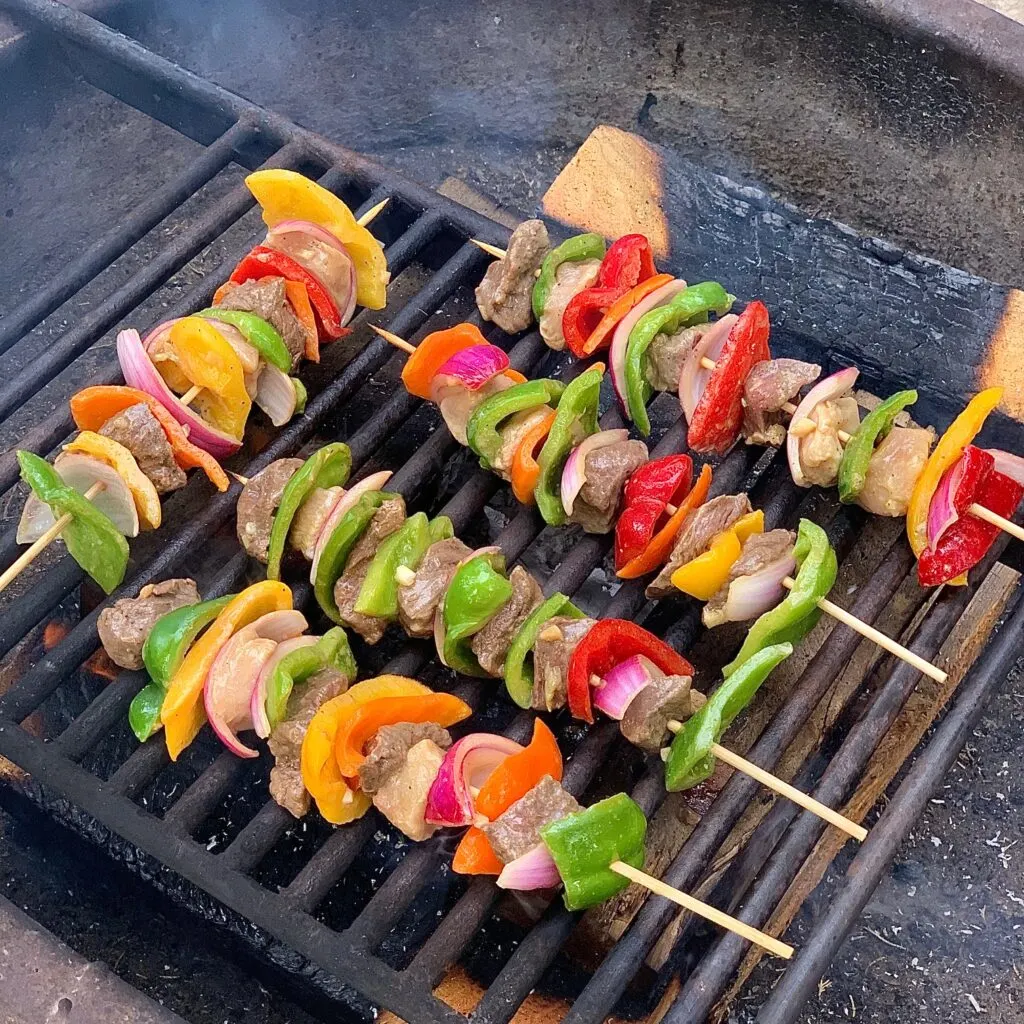 Colorful shish kabobs on wooden skewers grilling