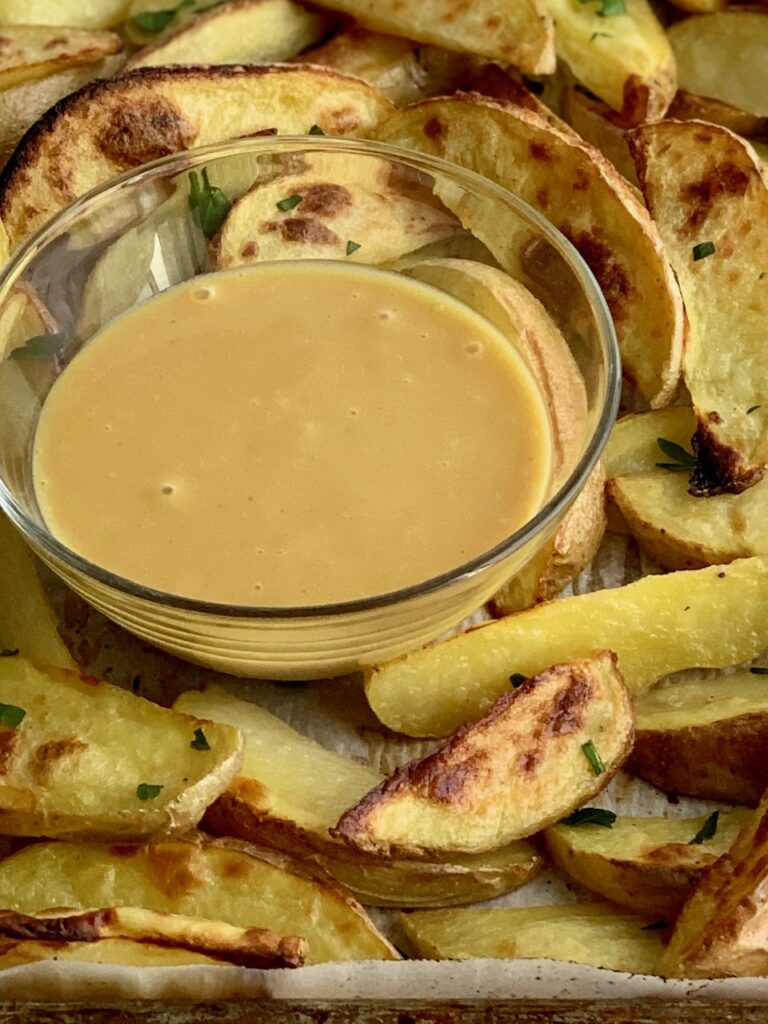 Homemade Chick-Fil-A Sauce in a bowl surrounded by baked potato wedges.