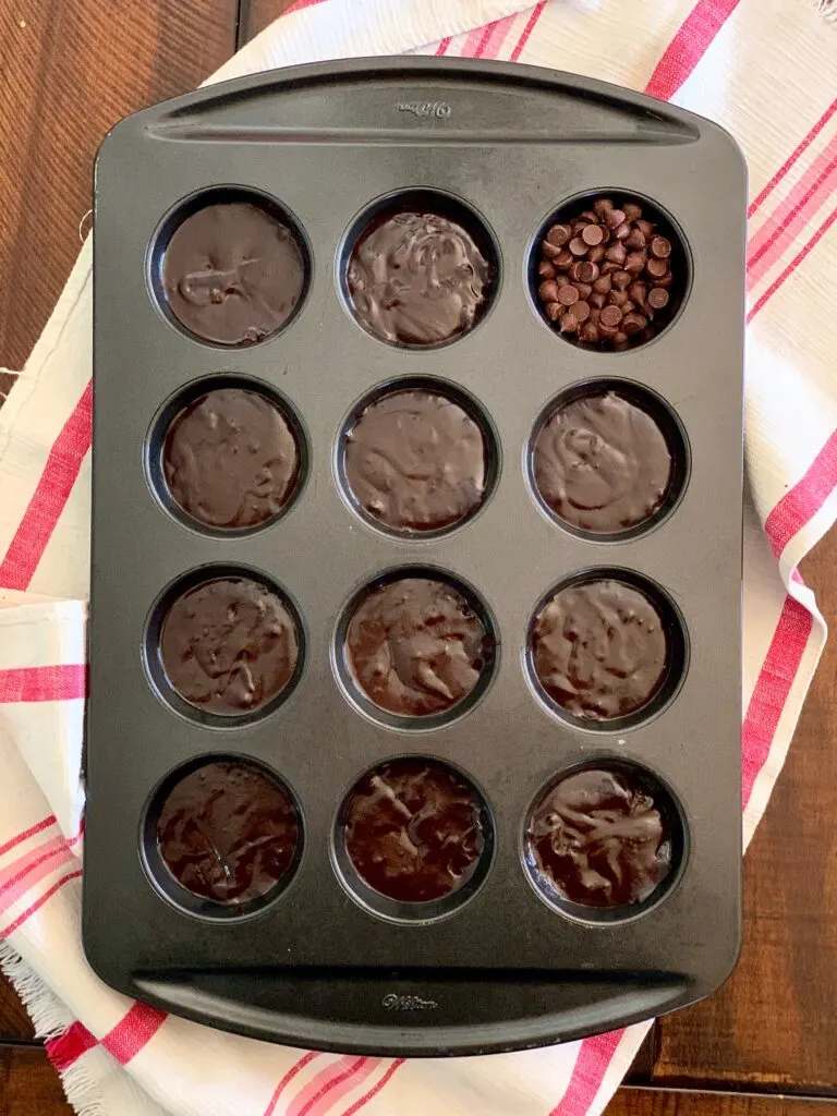 A muffin pan filled with brownie batter.