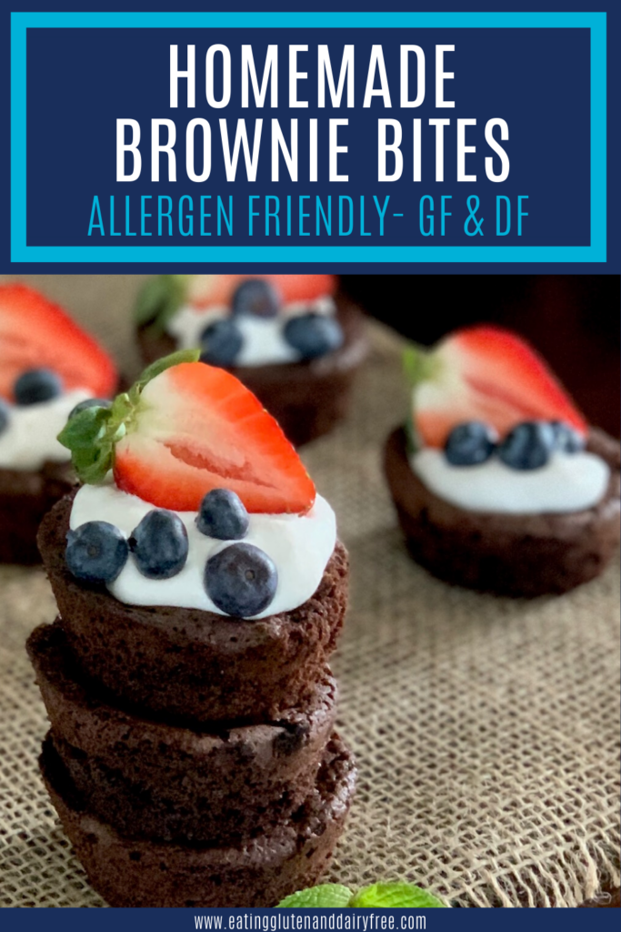 A stack of homemade brownie bites topped with dairy free whipped topping and fruit.