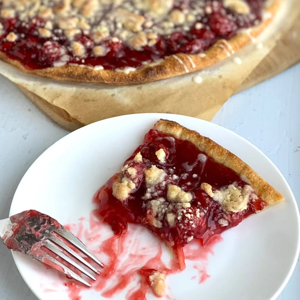 a half eaten slice of cherry dessert pizza