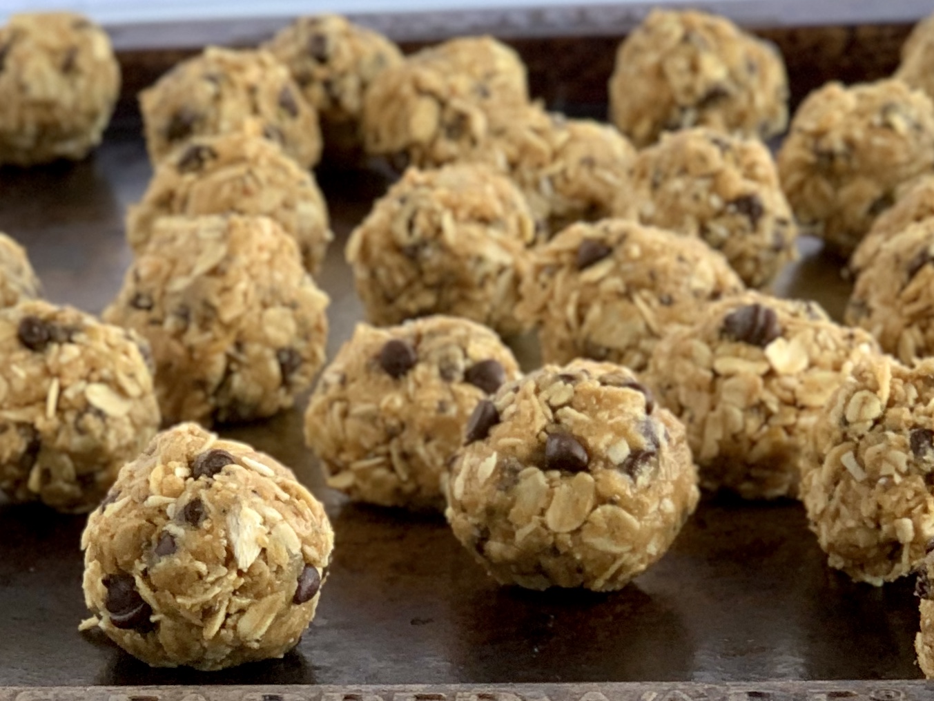 A baking sheet with a bunch of gluten free dairy free energy bites.