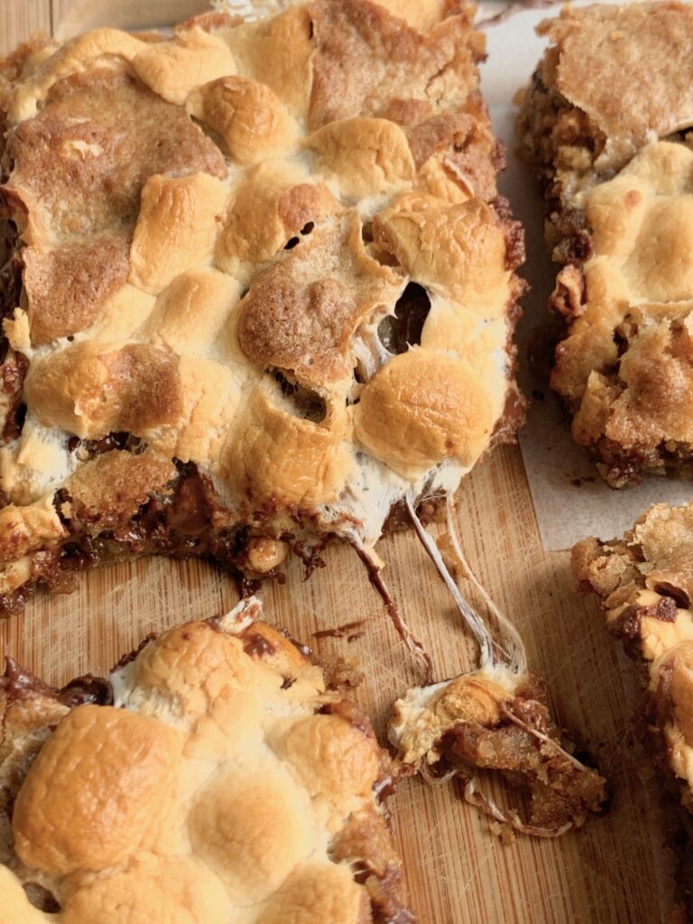 S'more cookie bars with gooey melted marshmallows oozing out.