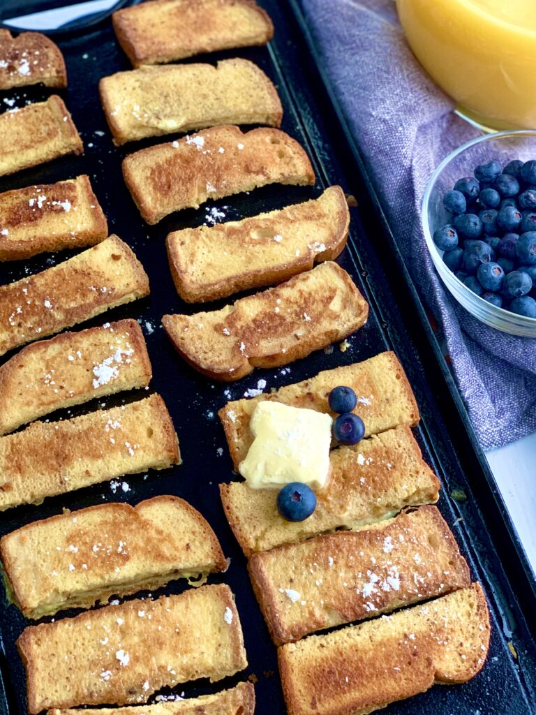 French Toast Sticks on a griddle with butter