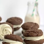 Buttercream frosting sandwiched between 2 brownie cookies.