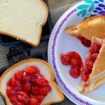 Pie filling on a slice of bread in a mountain pie maker.