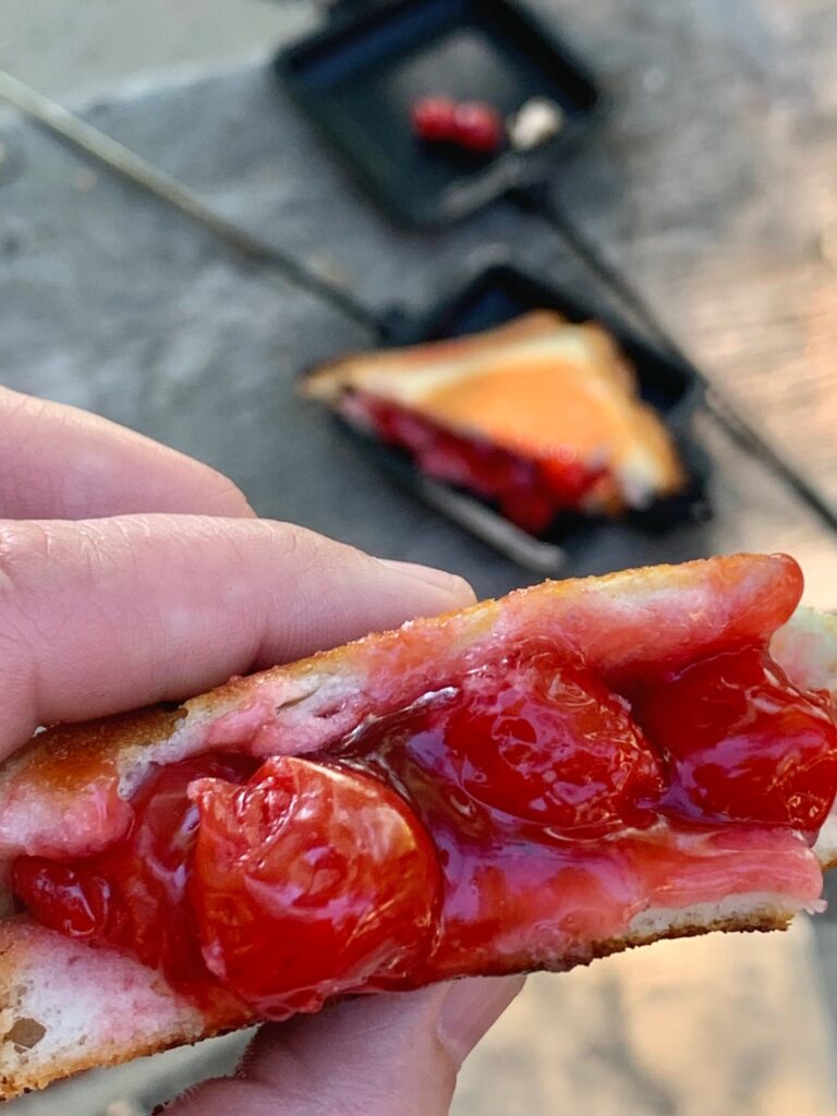 Cherry pie filling sandwiched between to slices of bread. 