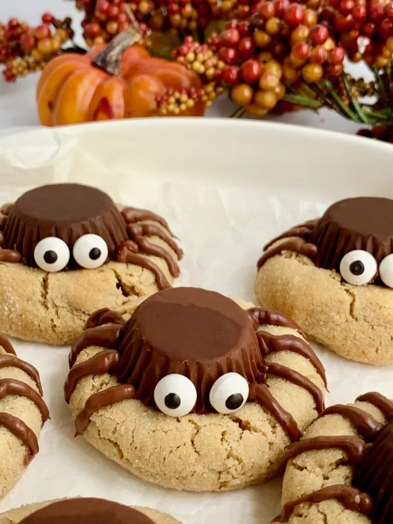 Peanut butter cookies with an upside down peanut butter cup, with edible eyes,  and frosting for 4 legs on each side.