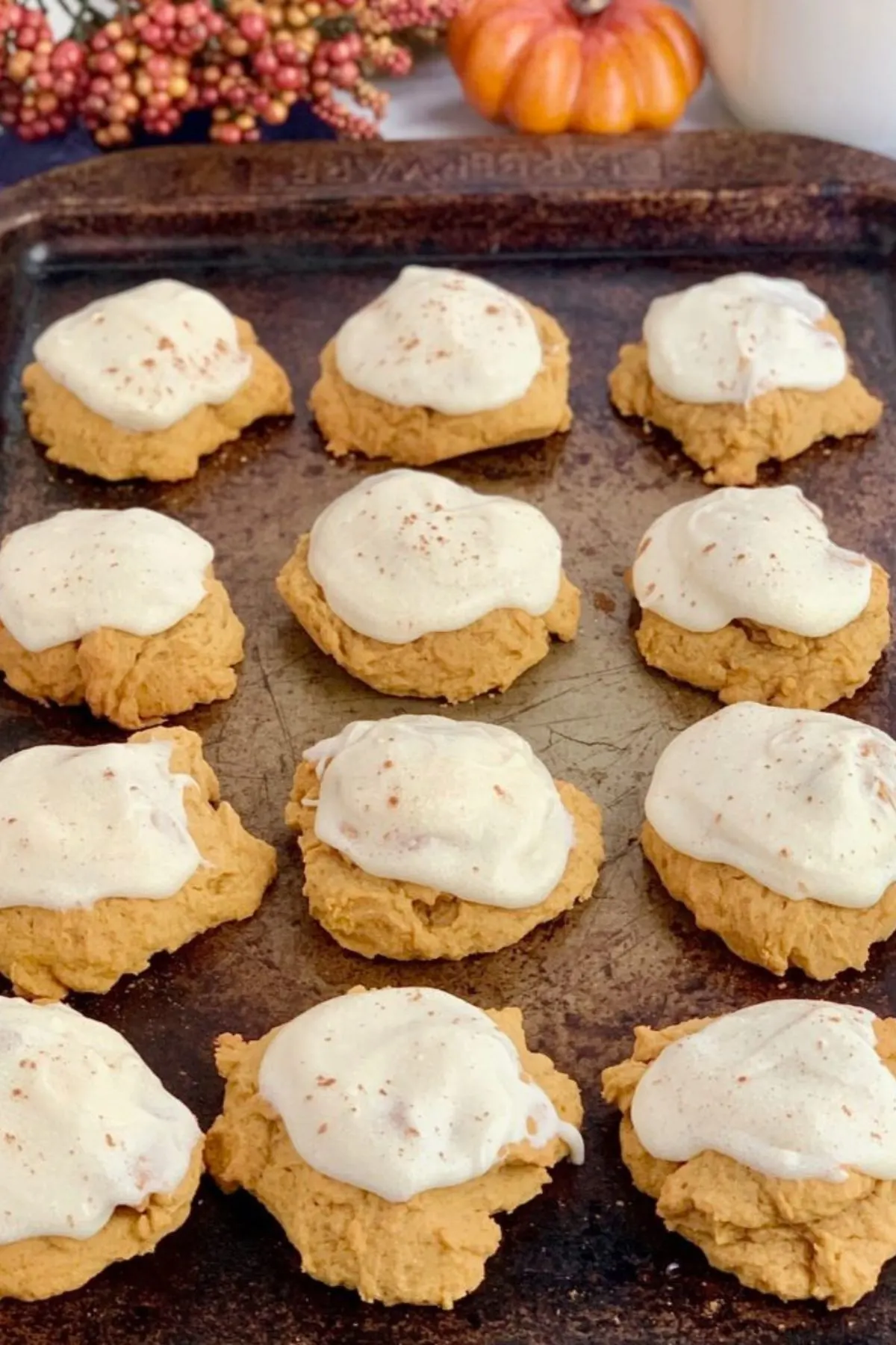 A baking sheet with frosted gluten-free pumpkin cookies