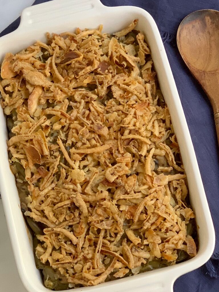 A baking dish with creamy mushroom soup. green beans, and crispy French fried onions on top.