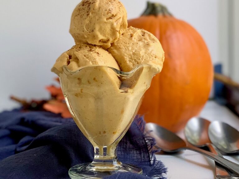 An old fashioned ice cream bowl with 3 big scoops of pumpkin ice cream.