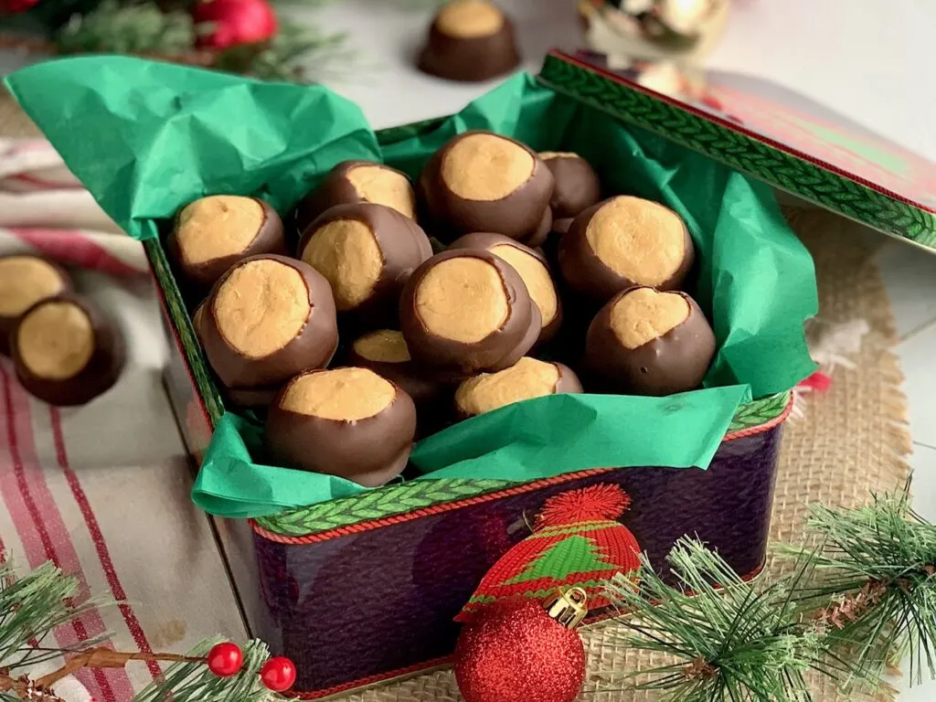 A Christmas tin filled  peanut butter balls dipped in melted chocolate.