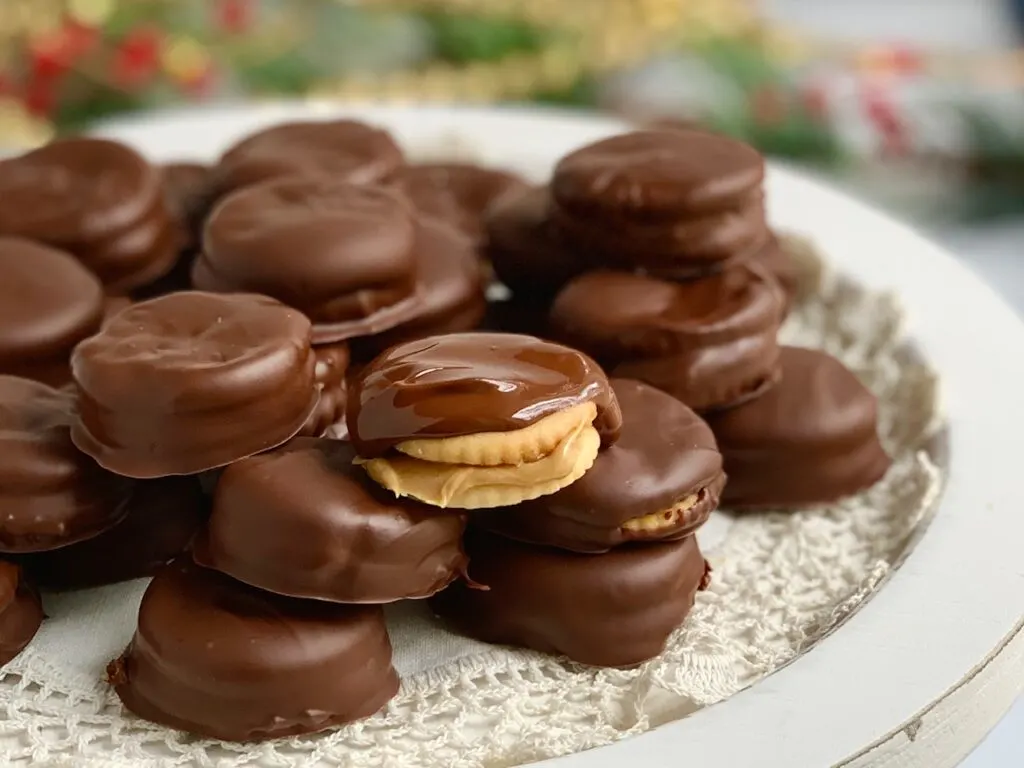 A platter full of peanut butter between two crackers then dipped in melted chocolate.