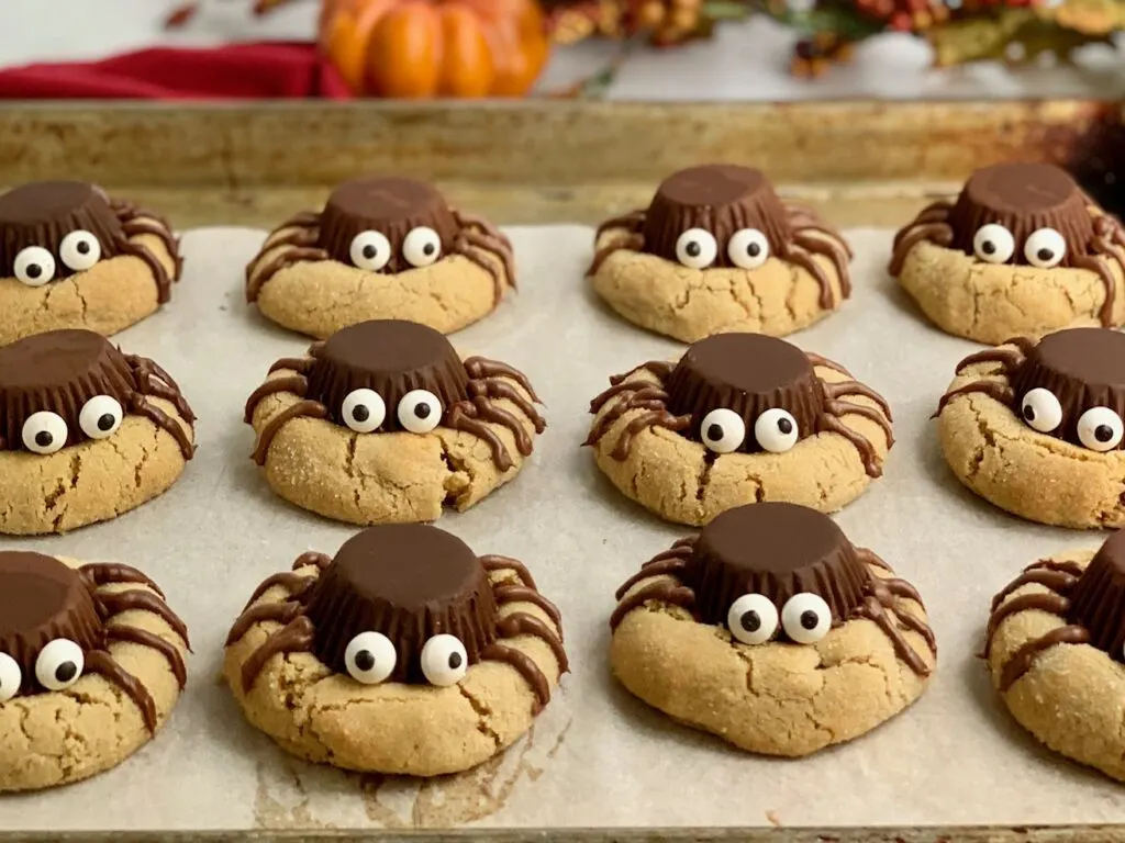 Peanut butter cookies with upside down peanut butter cups to look like spiders with edible eyes and frosting for legs.