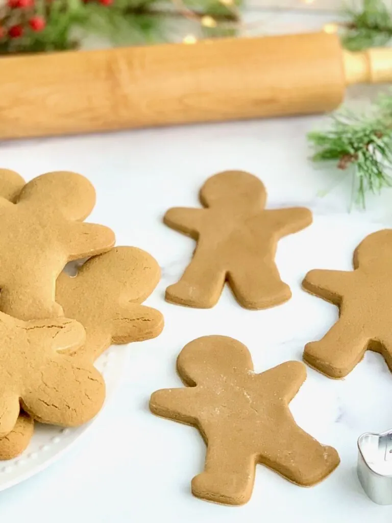 Gingerbread cookies on a countertop next to a rolling pin