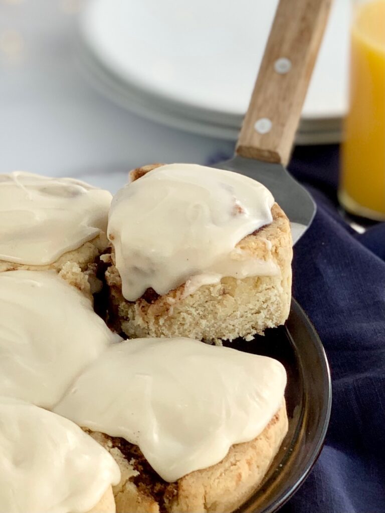 A pie plate full of 7 cinnamon rolls with a creamy cream cheese frosting.