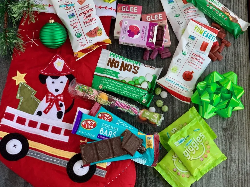 Several different allergen free snack ideas next to a red Christmas stocking.