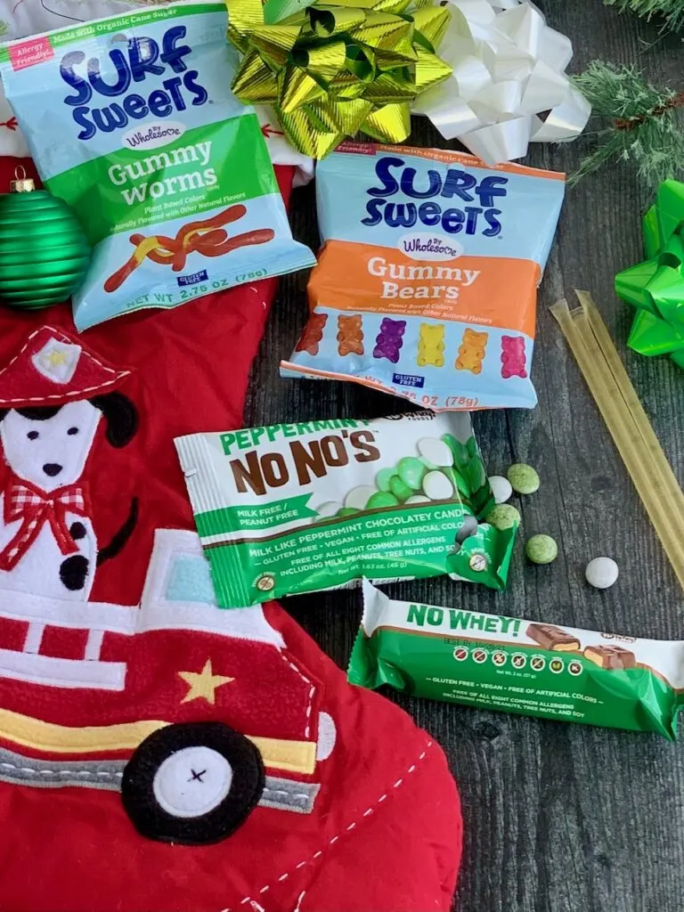 Several different allergen free snack ideas next to a red Christmas stocking.