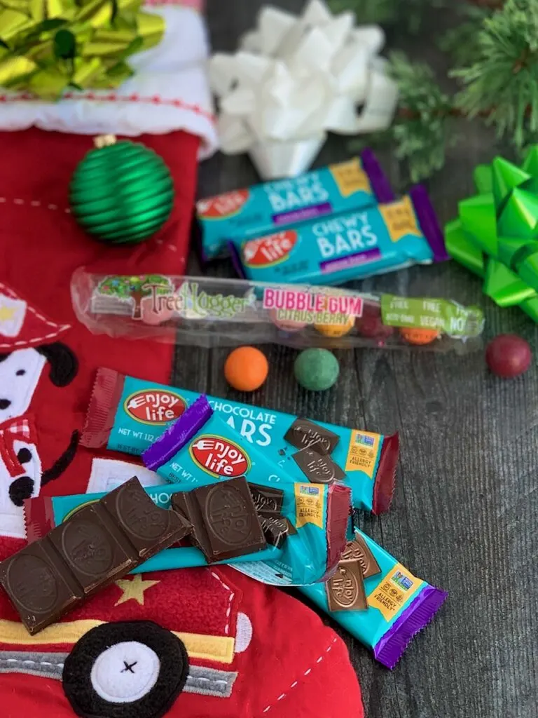 Several different allergen free snack ideas next to a red Christmas stocking.