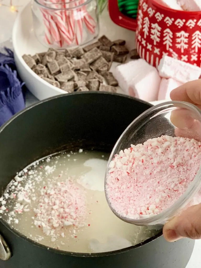 A mixture of granulated sugar, corn syrup, and crushed candy canes in a saucepan.