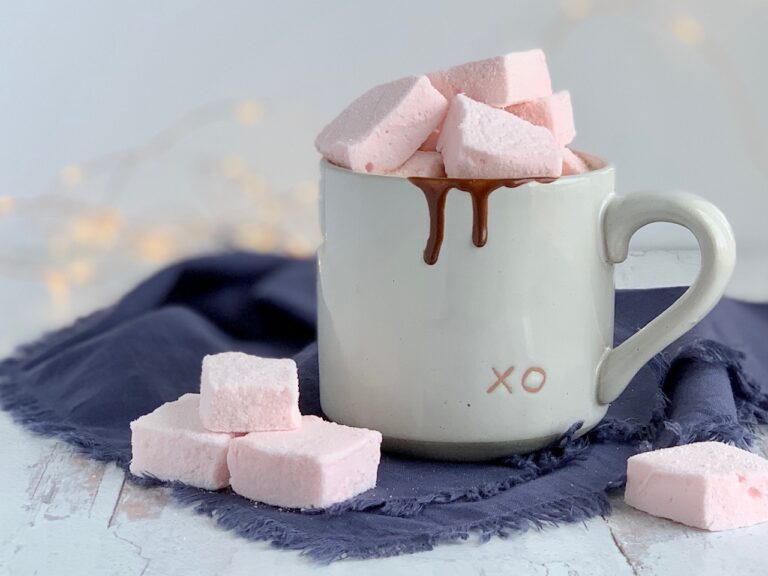 A white mug filled with hot chocolate and topped with homemade fluffy marshmallows