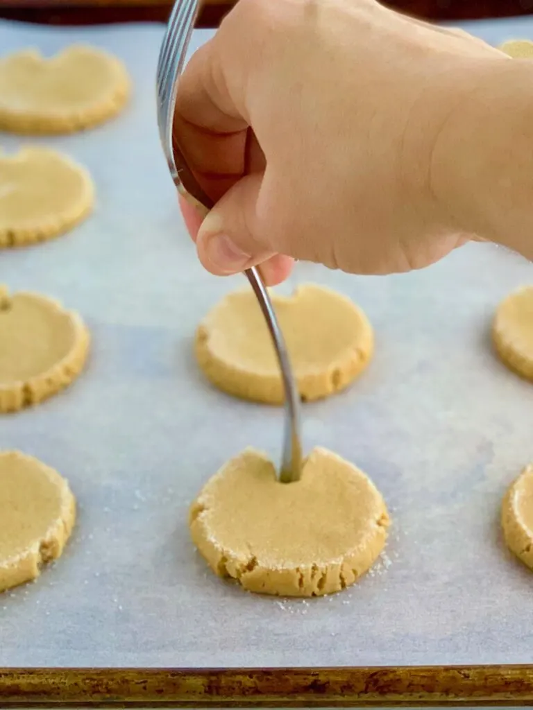 The dull end of a fork in the top of the cookie making a V shape.