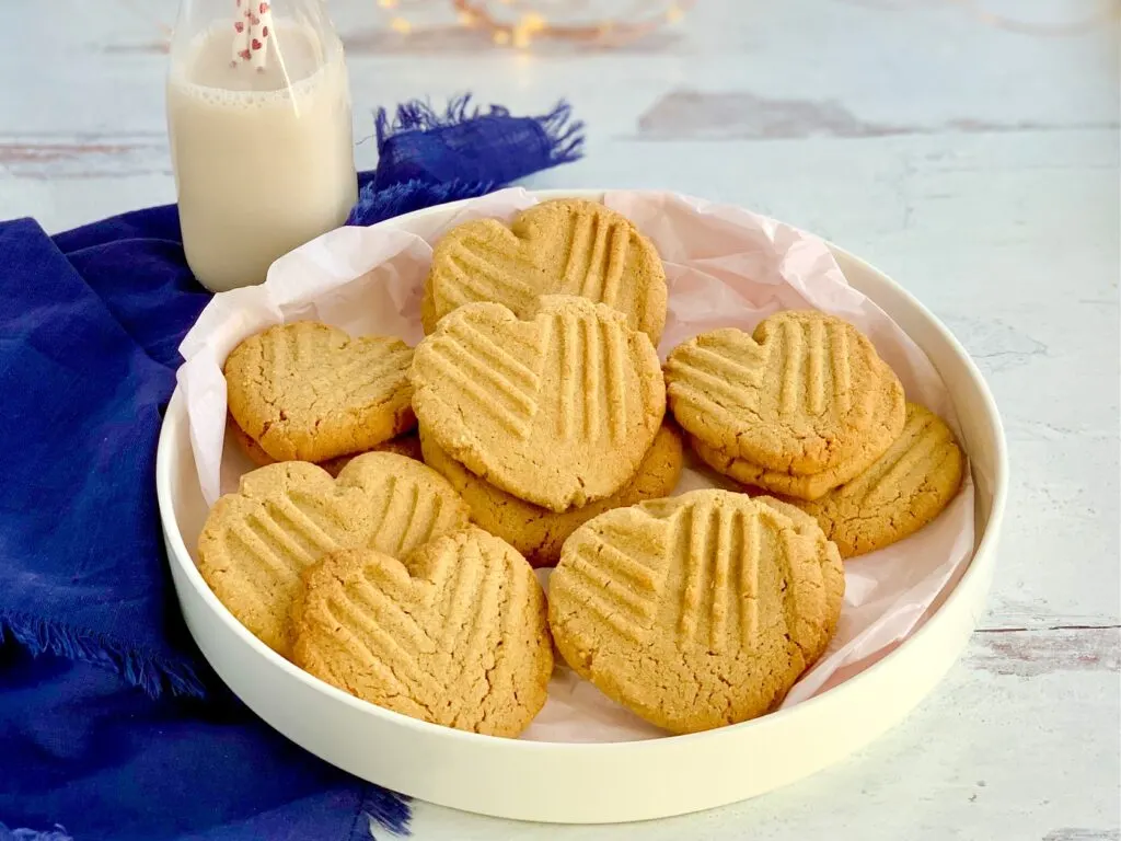 A platter full of heart shaped peanut butter cookies.