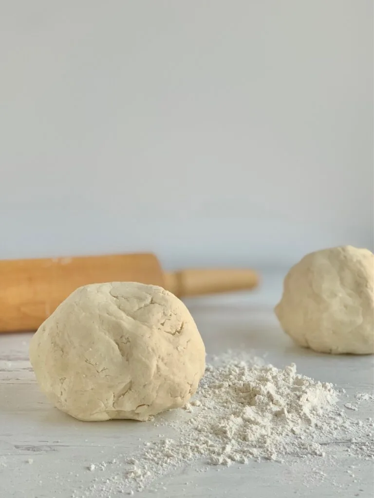 2 dough balls on a floured counter top
