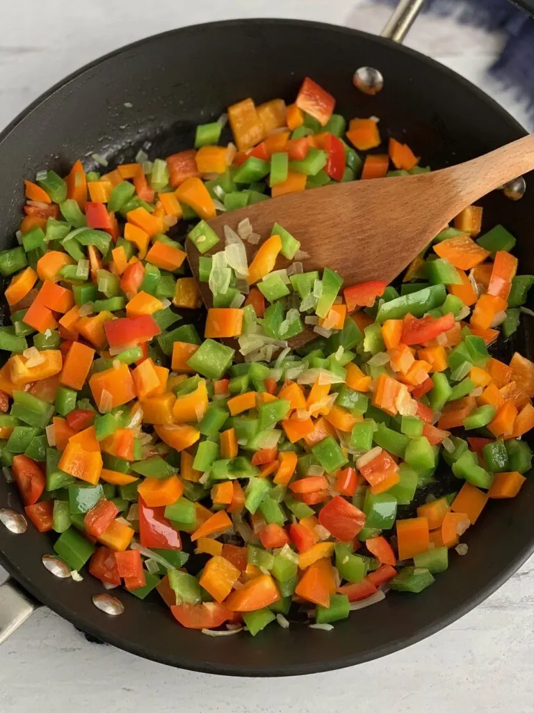 A skillet of sautÃ©ing onions, and bell peppers 